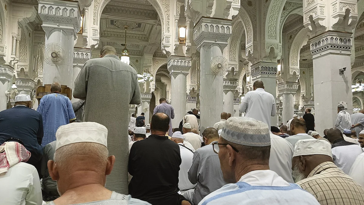 Rows of worshippers standing in prayer inside Masjid al-Haram during Ramadan