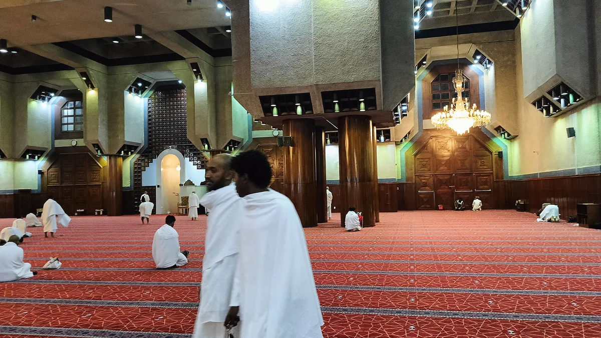 Pilgrims in white ihram inside the prayer hall of Masjid al-Tan'im in Makkah